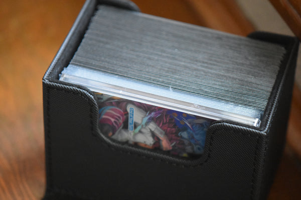 Doflamingo Alt Art Slim Player Slab inside of a black Ultimate Guard Sidewinder deckbox with a One Piece deck.