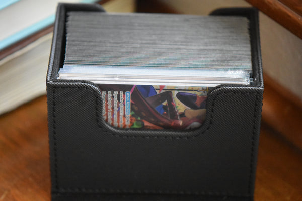 A One Piece Leader encased in a PCG Slim Player Slab inside an Ultimate Guard deckbox.