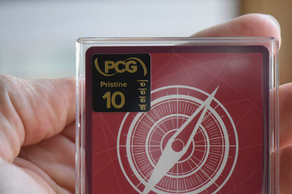 A closeup photo of a Pristine 10 PCG label on the back of a One Piece Leader card.