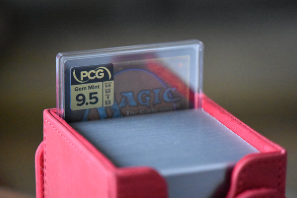 Korvold Rainbow Foil PCG 9.5 in a Slim Player Slab inside a red deckbox - back view
