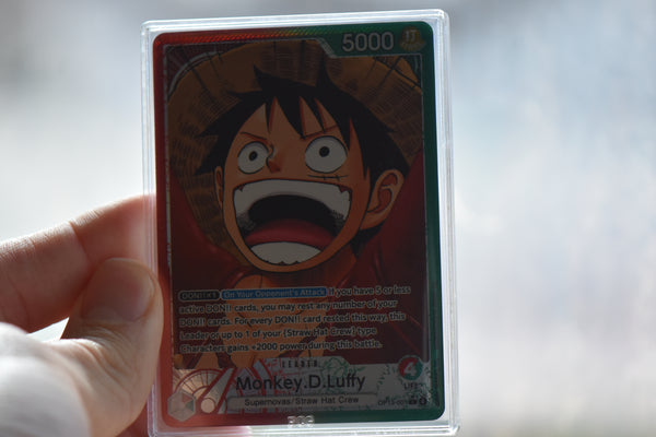 Hand holding a PCG Slim Player Slab featuring One Piece Leader Monkey.D.Luffy from OP13.