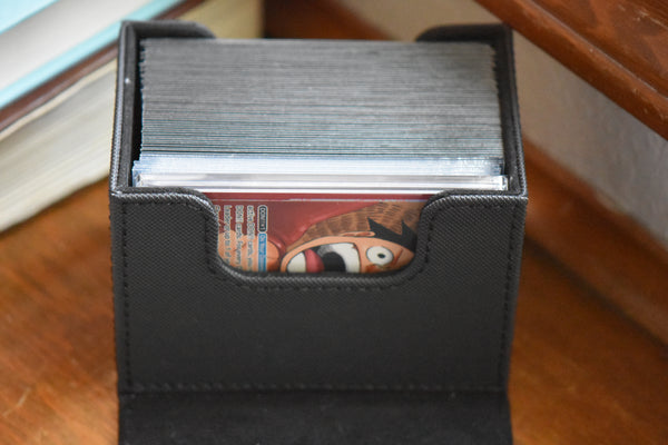 PCG Slim Player Slab inside of a black Ultimate Guard deckbox along with One Piece deck.