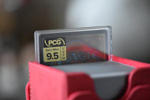 Gogo Surge Foil PCG 9.5 Gem Mint in a Slim Player Slab next to red deckbox - back view