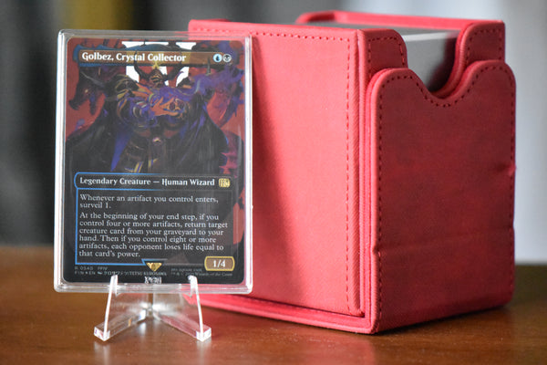 Golbez Surge Foil PCG 9.5 Gem Mint in a Slim Player Slab next to a red deckbox - front view