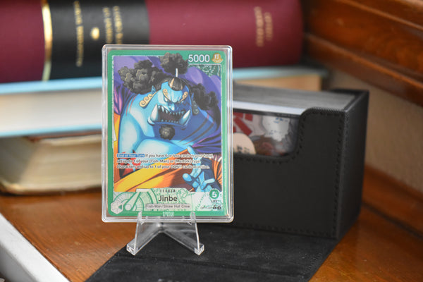 Jinbe Alt Art in a PCG 10 Pristine Slim Player Slab next to a black deckbox - front view.