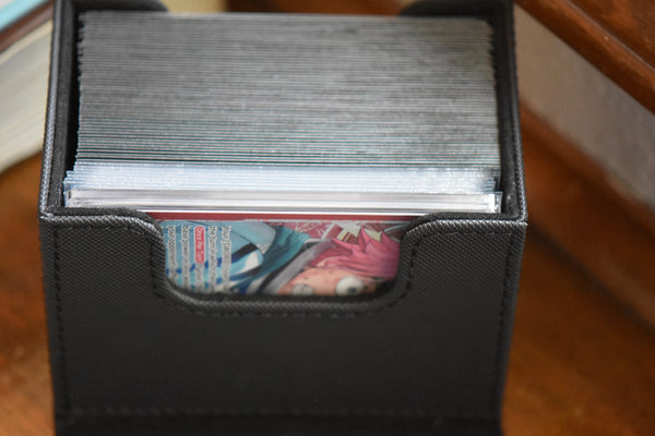 Koby Alt Art PCG 10 inside a black Ultimate Guard Sidewinder deckbox along with a One Piece deck and DON!!.