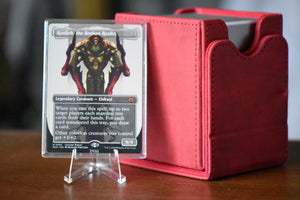 Kozilek Borderless PCG 9 Mint in a Slim Player Slab next to a red deckbox - front view