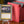 Oloro Judge Promo PCG 9 Mint in a Slim Player Slab next to a red deckbox - front view