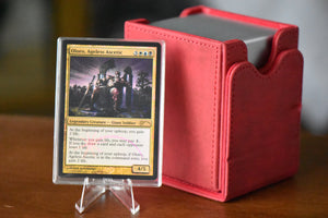 Oloro Judge Promo PCG 9 Mint in a Slim Player Slab next to a red deckbox - front view