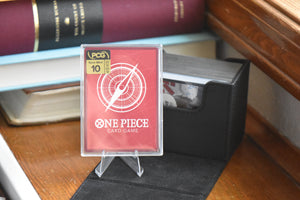 Sabo OP13 Alt Leader in a PCG Slim Player Slab next to a black deckbox - back view.