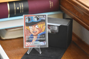 Sabo OP13 Alt Leader in a PCG Slim Player Slab next to a black deckbox - front view.