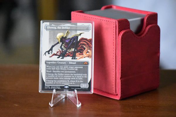 Ulamog Borderless PCG 9 Mint in a Slim Player Slab next to a deckbox - front view