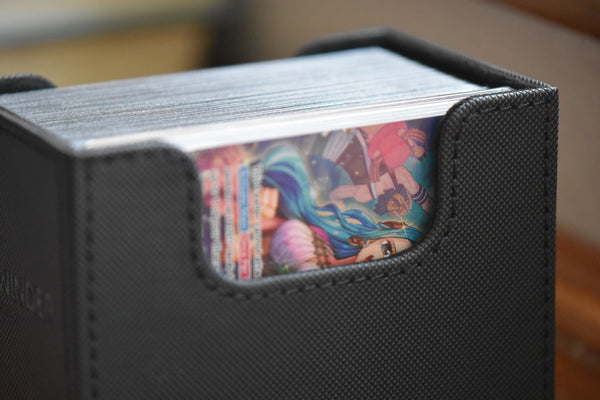 A graded One Piece Vivi Alt Leader inside a black Ultimate Guard deckbox.